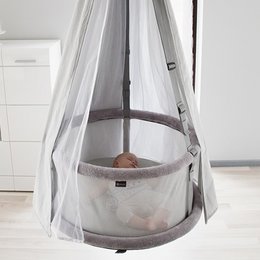 A premium 3-in-1 crib with a round, elevated design, featuring a white and gray color scheme and a mesh canopy.