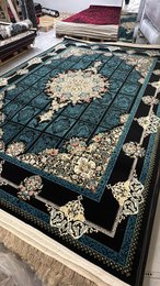 Large dark blue area rug with intricate floral and geometric patterns, suitable for living rooms or bedrooms.