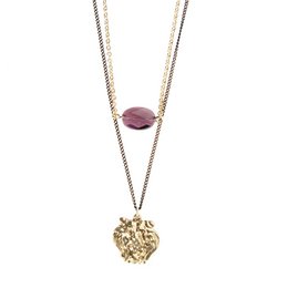 The Flooid Lion Duo Pendant features a gold or silver pendant with an amethyst or gunmetal accent. The pendant has a layered design with a lion-shaped charm and a round gemstone. This necklace would be suitable for casual or formal wear.