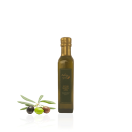 Extra virgin olive oil, 0.25 liters, harvest 2021. Green glass bottle with olive oil and fresh olives on a slate board.
The image shows a bottle of extra virgin olive oil, labeled as 0.25 liters and harvest 2021. The bottle is made of green glass and has a simple, elegant design. Next to the bottle, there are some fresh olives and a few slices of tomato on a dark slate board, along with some herbs or leaves, likely basil. The overall scene suggests a high-quality, artisanal olive oil product.