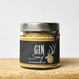 A jar of gin-infused mustard with a black label featuring a deer silhouette. The mustard has a rich, golden color and appears to be a specialty or gourmet product.