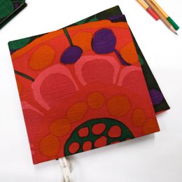  Handbound sketchbook with vibrant red, orange, purple geometric circles and organic shapes, colorful abstract design journal.