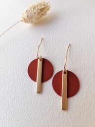 Elegant statement earrings featuring a round burgundy disc and a vertical bar in a gold-tone finish. Suitable for casual or formal wear.