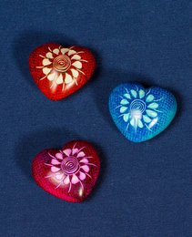 Decorative heart-shaped soapstone statues in red and blue colors, featuring intricate floral patterns.