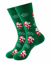 Green socks with Santa Claus and snowflake patterns, suitable for Christmas or holiday wear.
