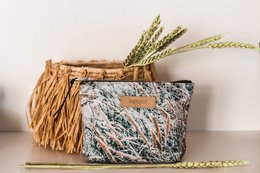 Small woven pouch in neutral tones with textured fabric, suitable for carrying small items.