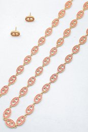 Ensemble assorti comprenant un collier, un bracelet en chaîne et une paire de boucles d'oreilles puces. Chaque bijou est composé d'une succession de maillons en forme de maille marine entièrement pavés de petits strass scintillants.