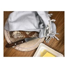 Handwoven placemat in a spade shape, made of blue and white woven material with a textured, natural fiber appearance.