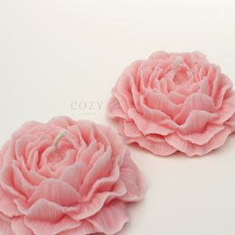  Peony-scented pillar candle available in a variety of neutral and pastel colors including cream, beige, brown, taupe, green, blue, pink, and yellow.