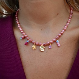 Gold plated necklace with crystal pearls and charms, suitable for formal or casual wear.
