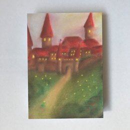 The image depicts a whimsical, fairy tale-inspired castle with red roofs and towers set against a green landscape. The castle appears to be the focal point of the image, with a path leading up to it. The overall style and composition suggest this is a greeting card or similar artistic representation of a fantasy castle scene.