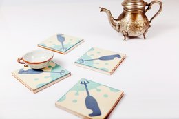 Set of 4 square coasters with abstract bird and geometric designs in pastel colors. Coasters are made of wood and have a cork backing for protection.