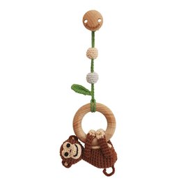 A 3-in-1 hanging toy monkey named Charlie in a brown organic color. The toy features a wooden ring, crocheted monkey figure, and various textured elements like leaves and beads.