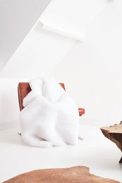 Soft, plush white faux-fur throw with natural silk lining. Rectangular shape, ideal for cozy home decor.