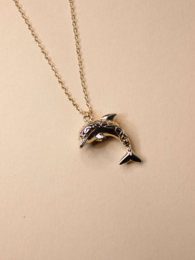 Gold-toned dolphin charm necklace with black accents.