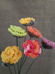  A vibrant, handcrafted artificial rose in a deep red color, with a textured, layered petal design and a sturdy stem.