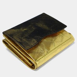 A modern statement wallet made of paper in a gold and black color scheme. The wallet has a minimalist, sleek design and is made of durable materials.