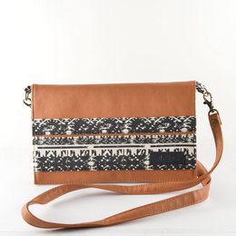 Caramel-brown handbag with a black and white patterned design. The handbag features a detachable shoulder strap and a flap closure.