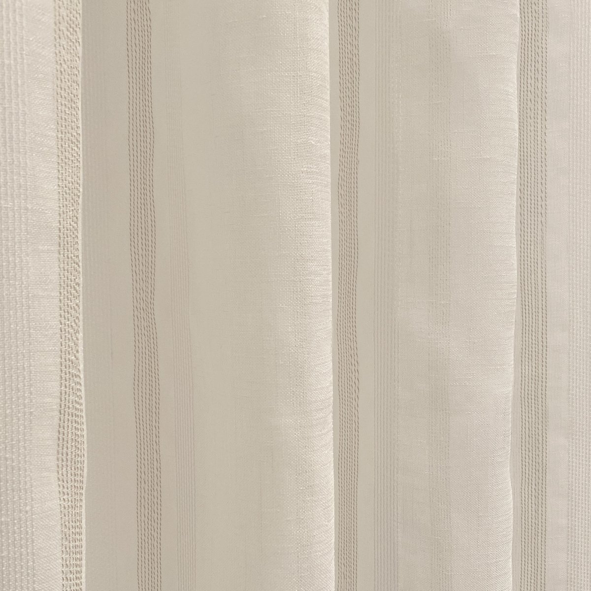 Cortina translúcida de color beige confeccionada en cinta multifunción (cinta fruncidora o pasabarras). Visillo Jacquard de raggi verticali fabbricato con materiali riciclati e di qualità. Colori naturali e caldi. Cortinas para salón, dormitorio