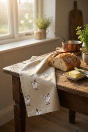  Chicken-patterned tea towel made of cotton material with a soft, absorbent texture. Features a repeating design of cartoon-style chickens in various colors.