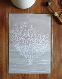 A framed poster featuring a white coral design on a light background. The poster is titled "Coral Of The Sea" and is described as sustainable art prints on recycled paper in cellophane.
