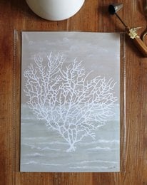 A framed poster featuring a white coral design on a light background. The poster is titled "Coral Of The Sea" and is described as sustainable art prints on recycled paper in cellophane.