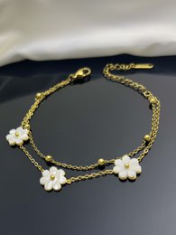 Double flower bracelet in natural mother-of-pearl with golden or silver chain and floral accents.