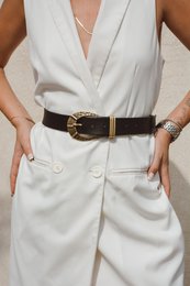 Black leather belt with ornate gold-tone buckle, suitable for casual or formal wear.