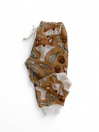 Cotton sweatpants with a woodland caramel pattern featuring leaves, acorns, and other natural elements. Available in sizes 1-3 years through 5-6 years.