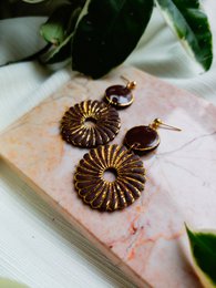 Spiral earrings in brown and gold tones, featuring a statement design with intricate patterns and a bold, eye-catching appearance. Suitable for formal or casual wear.