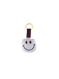 Smiley face keychain, white mousseline fabric, brown accent, happy expression charm.