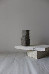 A handmade, matte gray vase with a simple, cylindrical shape.