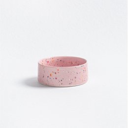  Two round, speckled pet food bowls in pink color. The bowls appear to be made of ceramic or a similar material.