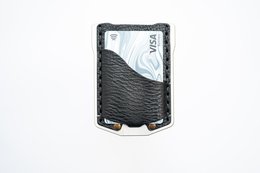 Black leather wallet with textured pattern and metal accent. Compact design for everyday carry.
