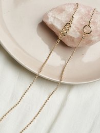 Stylish gold or silver eyeglasses with delicate chain necklace featuring geometric pendant and dangling beads.