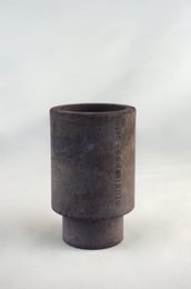 Cylindrical concrete tea light holder in black, terracotta, and white colors.