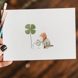 Postcard with a four-leaf clover and a squirrel, representing good luck.