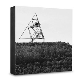 Geometric tetrahedron-shaped poster featuring a black and white image of a triangular structure against a forested background. Available in 10x10cm, 15x15cm, and 20x20cm sizes.