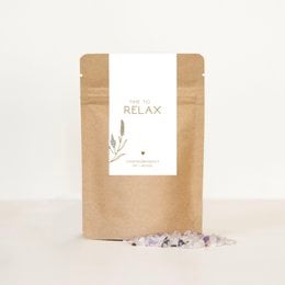 Relaxing bath salts in a natural kraft paper bag with a simple label design featuring a leaf illustration.