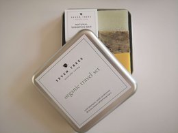 Organic travel set, includes soap, shampoo, and conditioner in a reusable tin container.