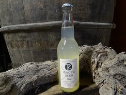 Ginger beer, 330ml, organic, glass bottle, carbonated, golden yellow color, served in glasses against natural background.