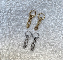 Chain earrings in gold and silver colors. Hoop-style earrings with circular metal charms.