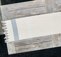 Handwoven table runner with fringe detail, suitable for bridal or formal table settings.