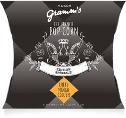 Boxes of 30g caramel Curry Mango popcorn, featuring a bold graphic design with elephants and a vibrant yellow accent.