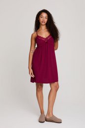 A burgundy-colored, sleeveless, knee-length dress with a pleated bodice and a flowing, A-line skirt. The dress has a V-neckline and thin spaghetti straps.