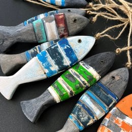 Decorative wooden fish sculptures with colorful painted stripes and patterns. The sculptures have a rustic, handmade appearance and are suitable for use as home decor or wall art.