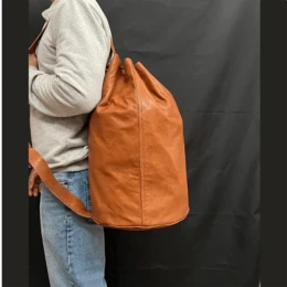  Handcrafted leather cylindrical duffel bag in black, light brown, and dark brown colors. Made of high-quality leather with a cylindrical shape, suitable for athletes and travelers.