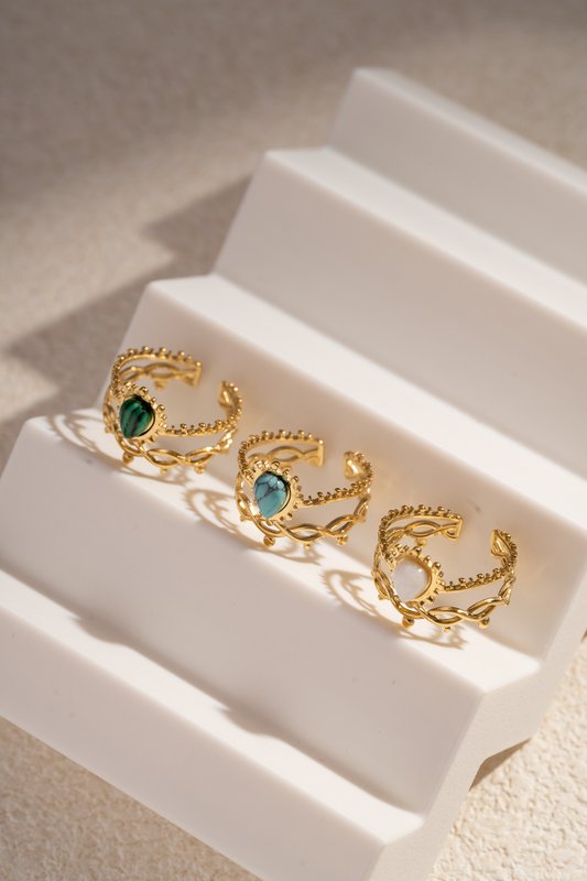 Golden stalen ring geopend met kleurrijke steen