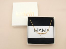 A delicate gold-plated necklace with the word "MAMA" in a stylish font, presented in a sleek black gift box. This thoughtful jewelry piece is a perfect gift for mothers.