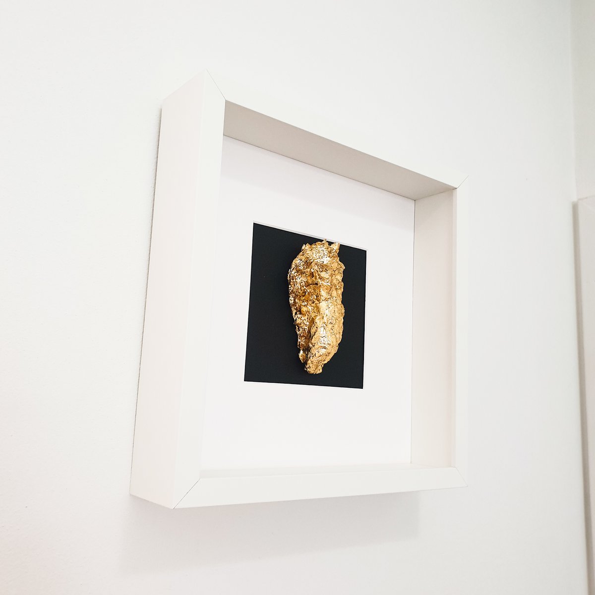 Gouden oester in houten witte lijst